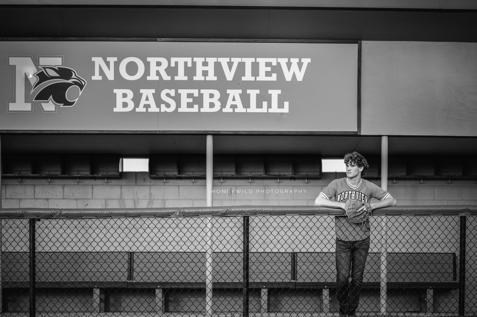 Senior boy baseball player in dugout