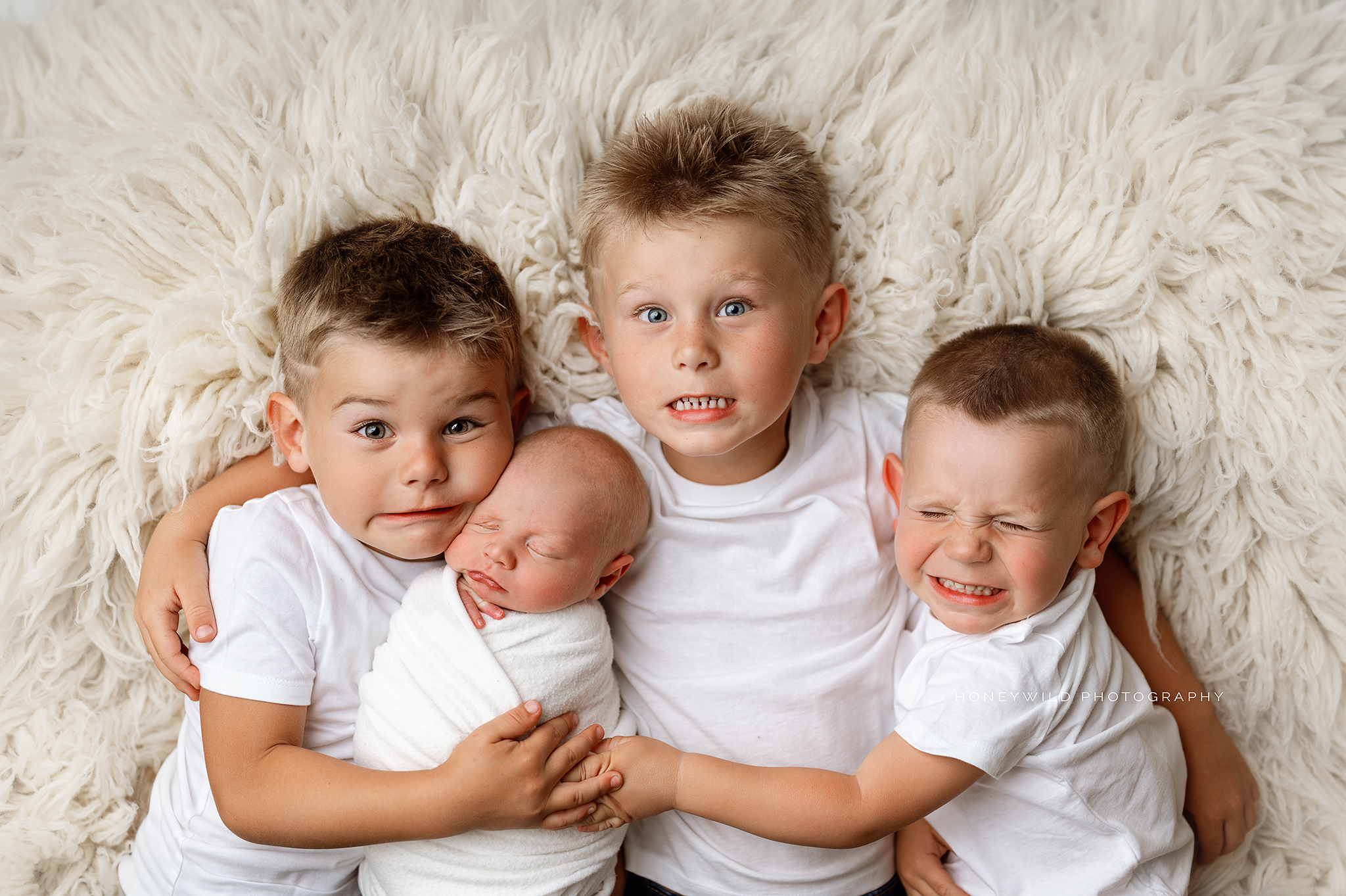 Newborn baby with his three older brothers