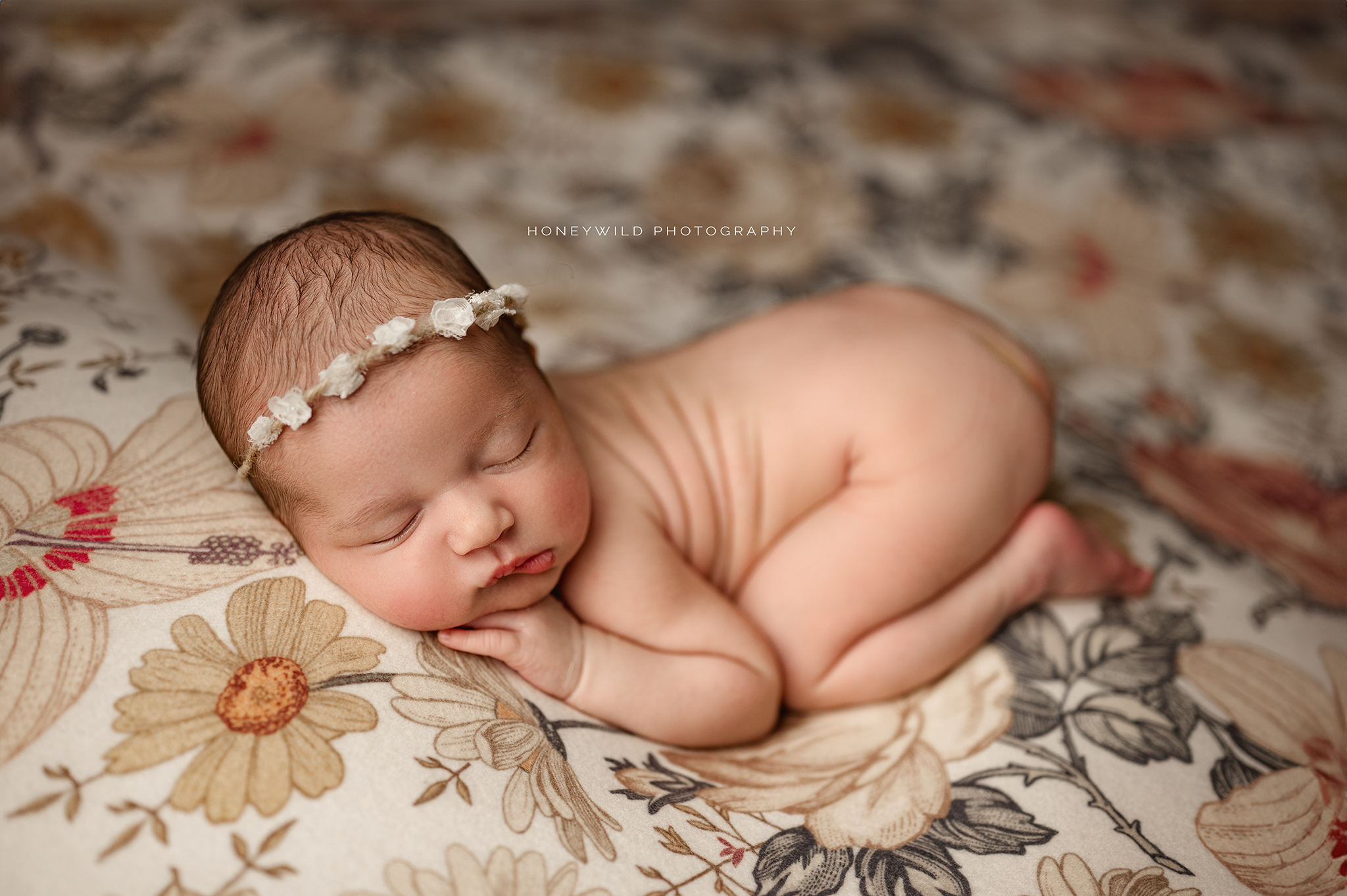 Newborn sleeping on wildflowers