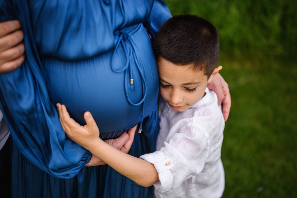 Big brother hugging moms belly at a Grand Rapids Maternity session