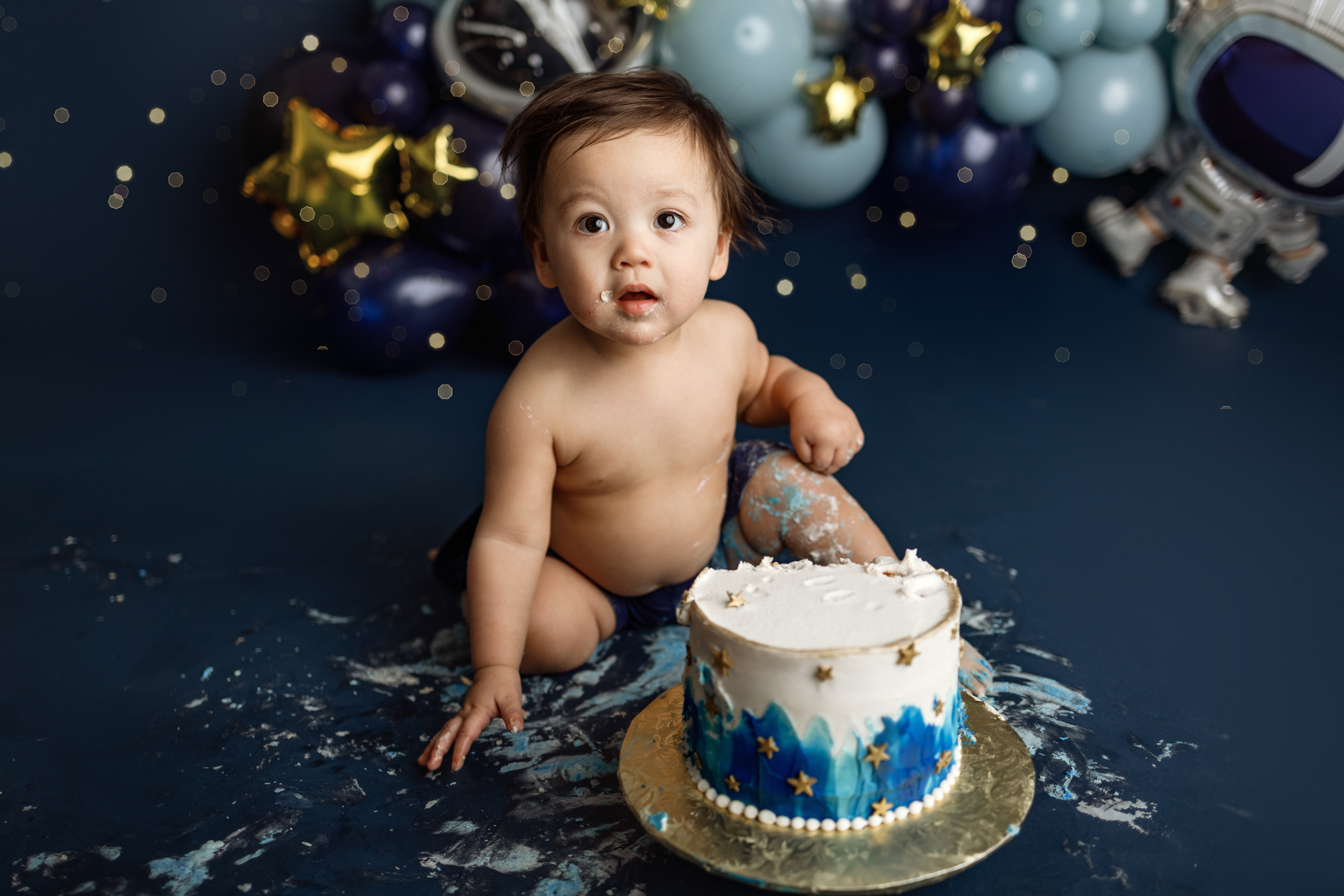 Space-themed first birthday cake smash session by Grand Rapids newborn photographer