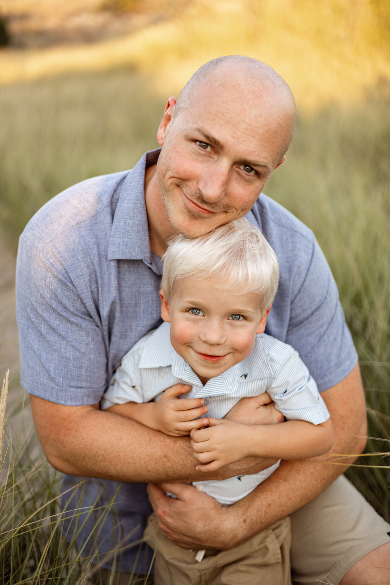 Grand Rapids family photographer capturing joyful outdoor portraits of a dad with his two young children. Natural family photography in West Michigan for authentic memories.