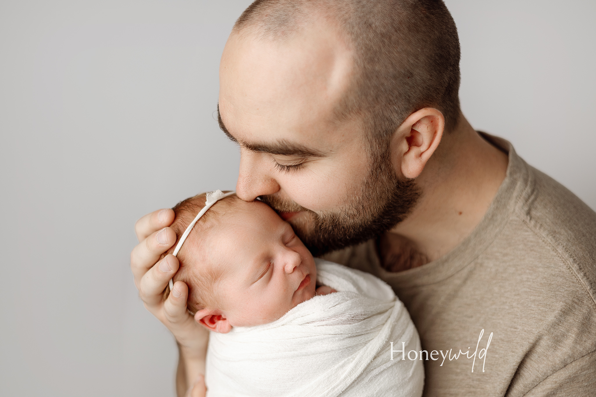 Grand Rapids newborn photography featuring tender moments between a father and his baby. Specializing in intimate newborn sessions in West Michigan.