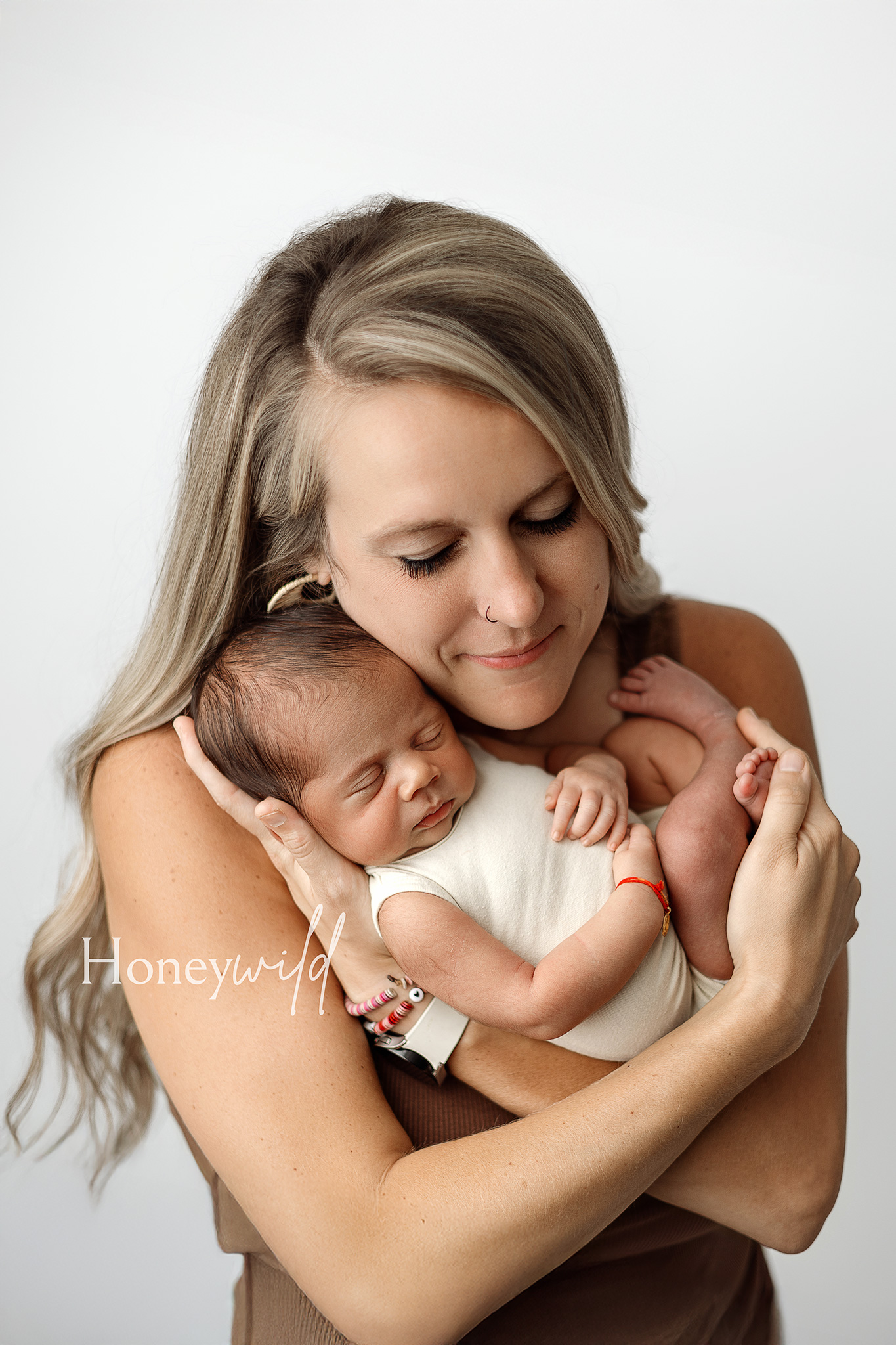 Soft, intimate portrait of a mother cradling her newborn baby, photographed by Honeywild Photography specializing in newborn photography in Grand Rapids, MI