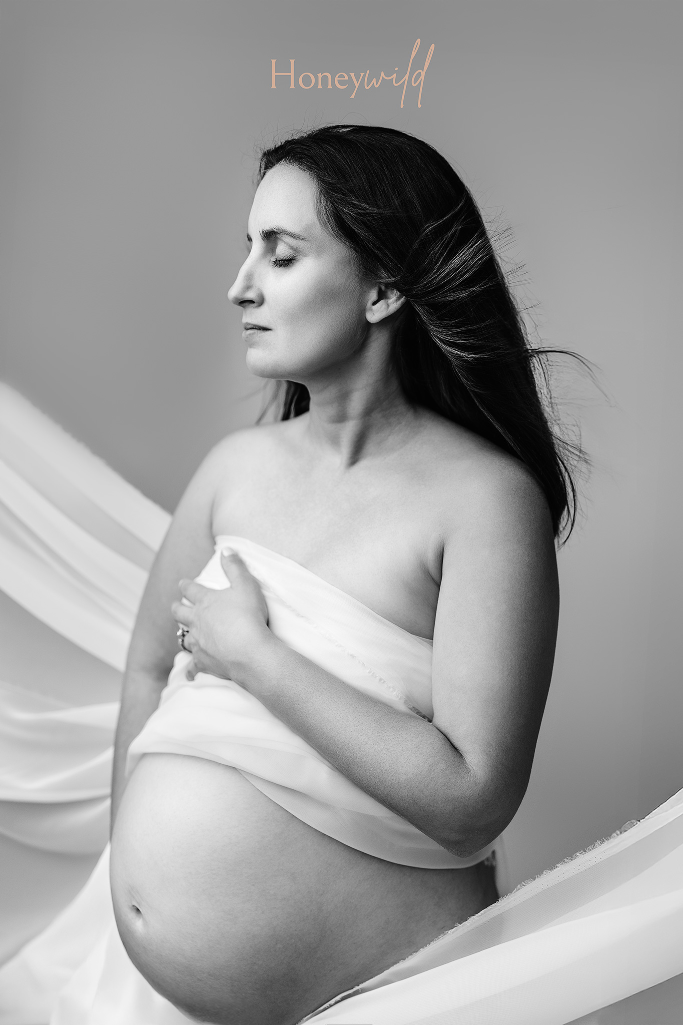 Black and white silhouette maternity portrait highlighting the shape of pregnancy in a fine art studio setting