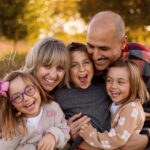 Grand Rapids family photography session taken in golden hour light with smiling faces on all family members