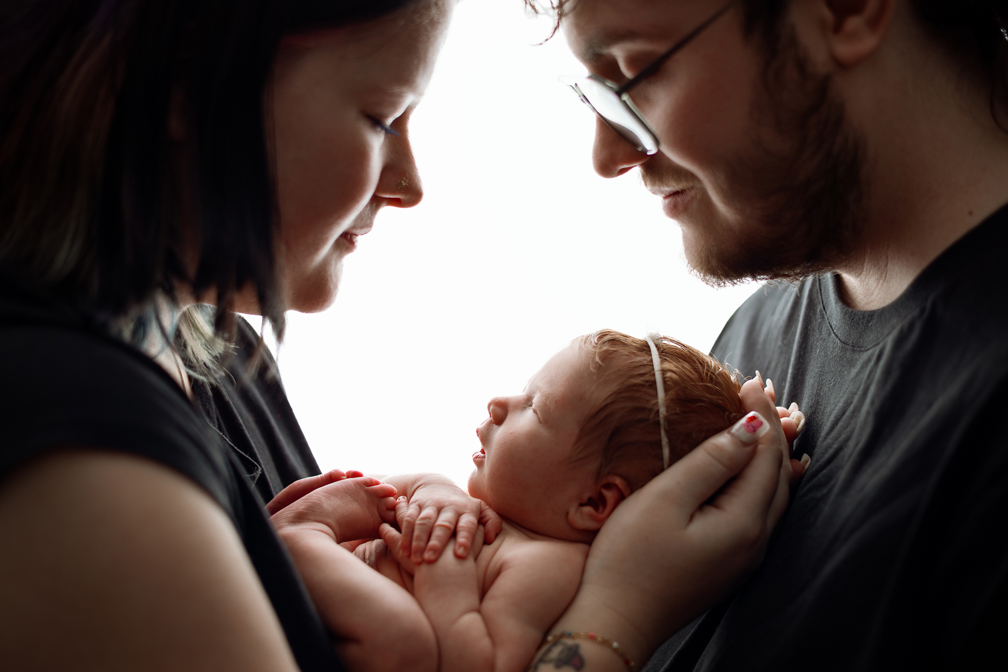 Calm newborn photography session with parent holding baby in soft natural light at Honeywild Photography studio in Grand Rapids, Michigan