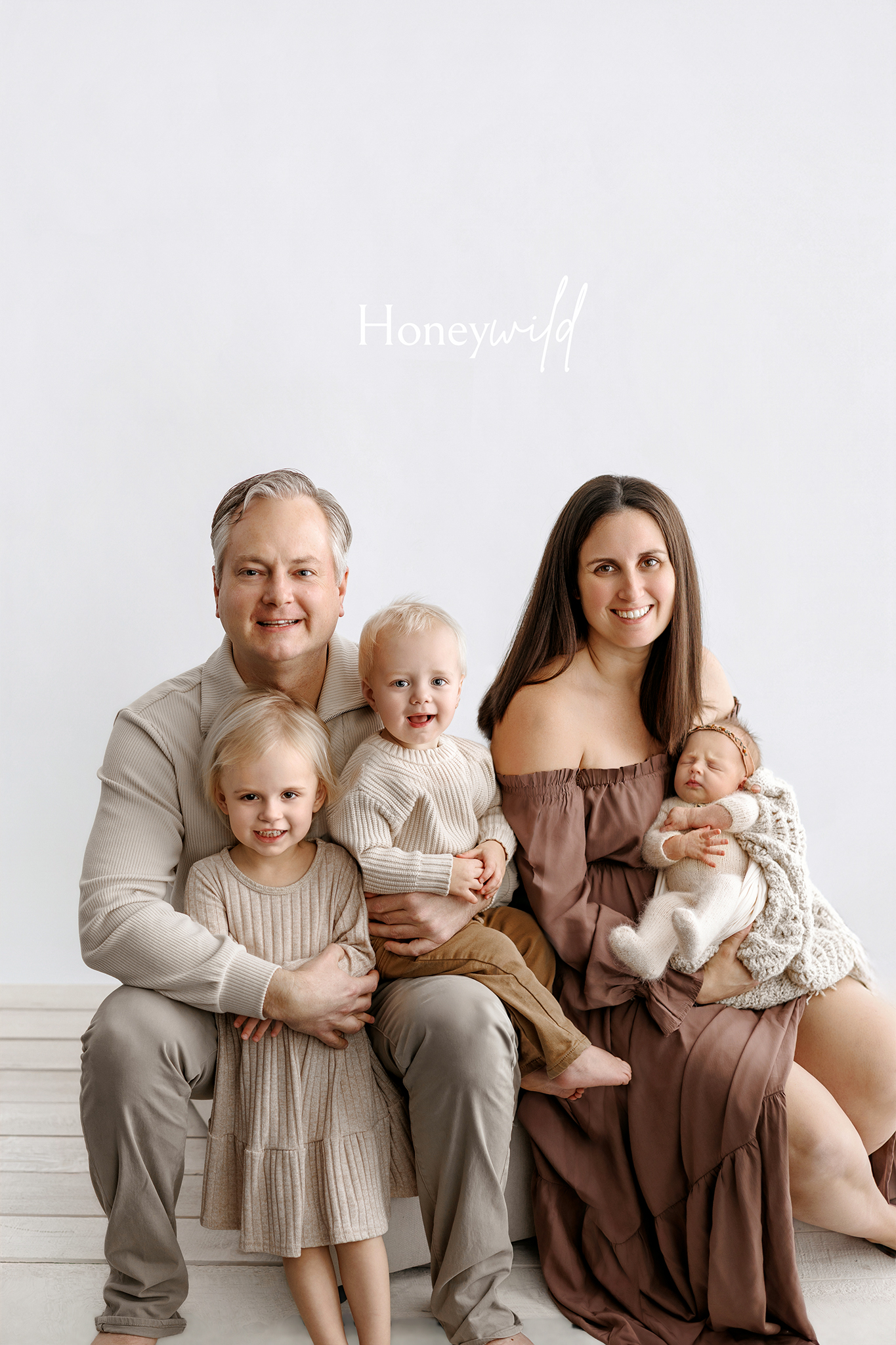 Artistic newborn family image with neutral styling and soft light