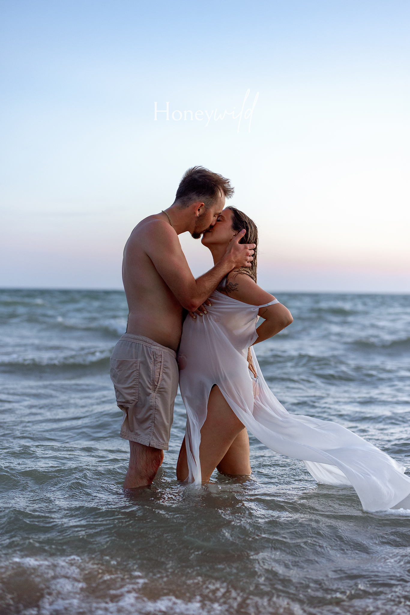 Couple kissing in Lake Michigan surf at sunset, Saugatuck Michigan couples and maternity photography.