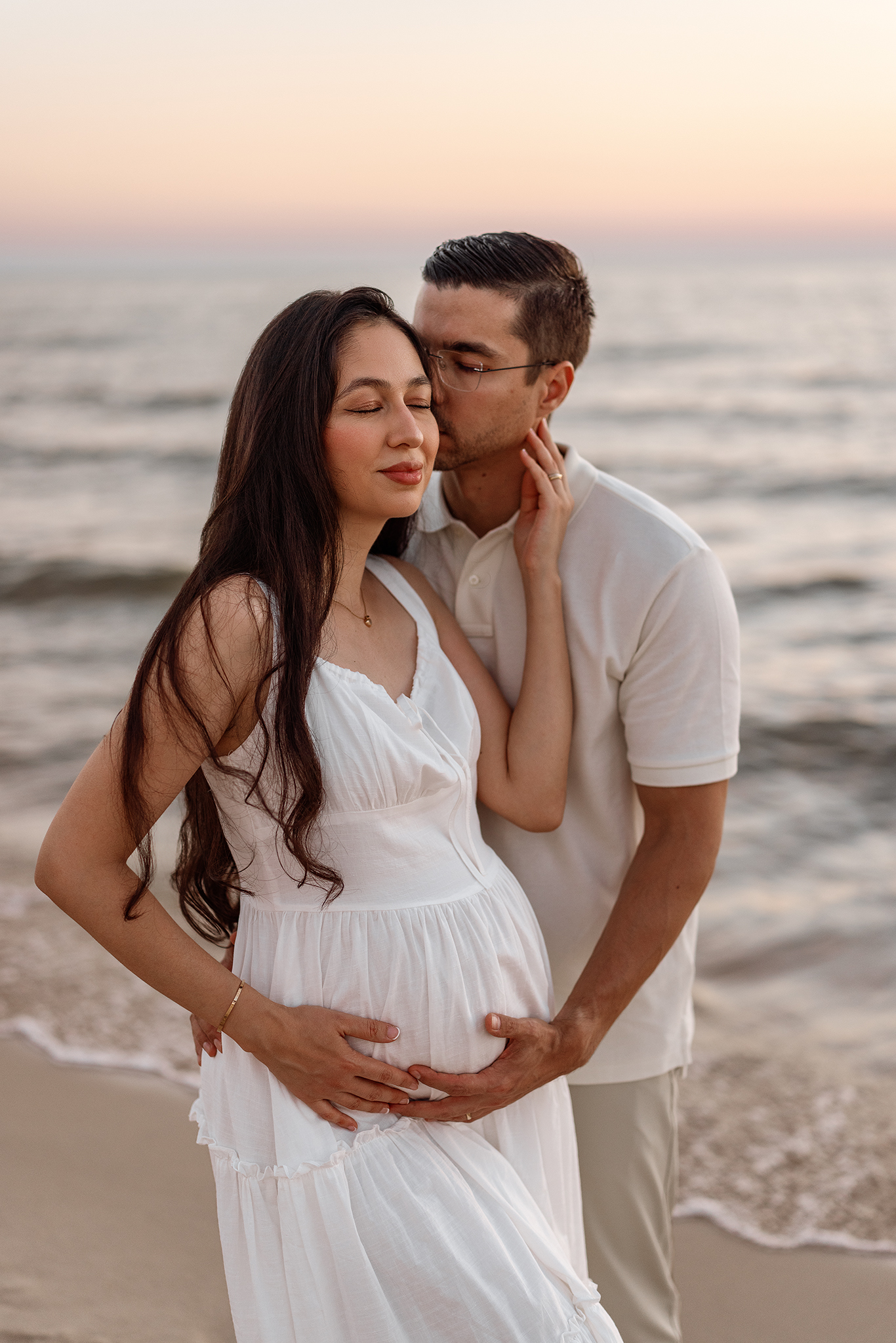 maternity session at lake michigan, dad holding moms belly tenderly mom in white dress