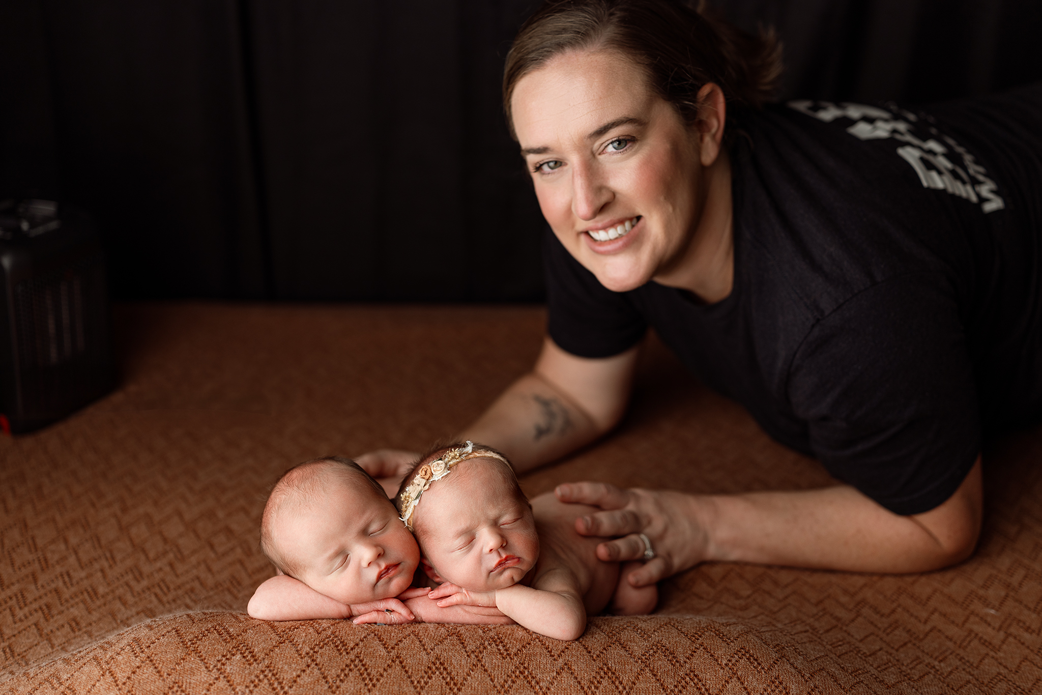 Grand Rapids newborn photographer poses twin babies during a studio session, hands resting gently on each baby